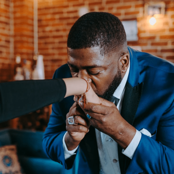 A man kissing a woman’s hand