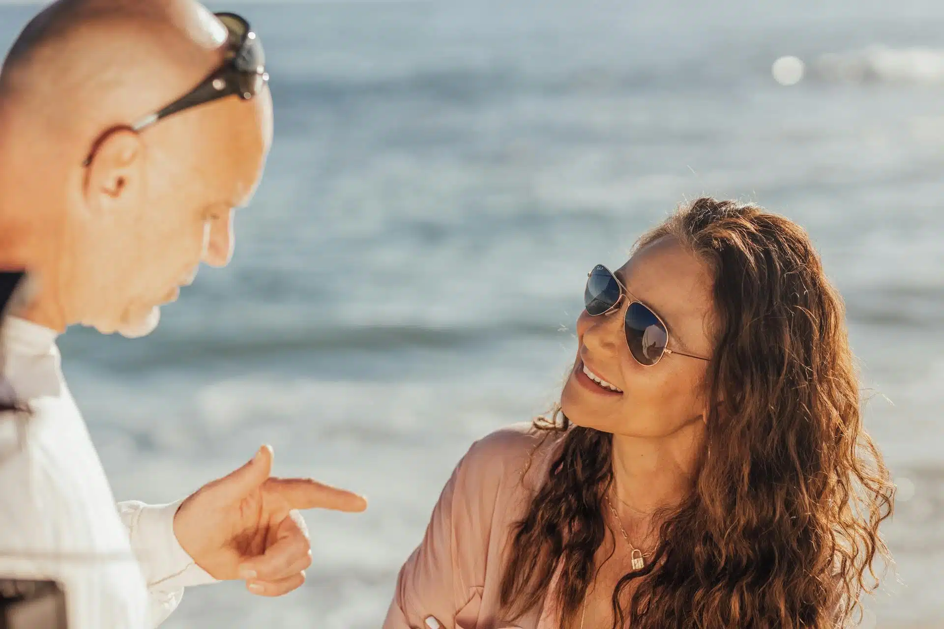 A man and woman talking at the beach.