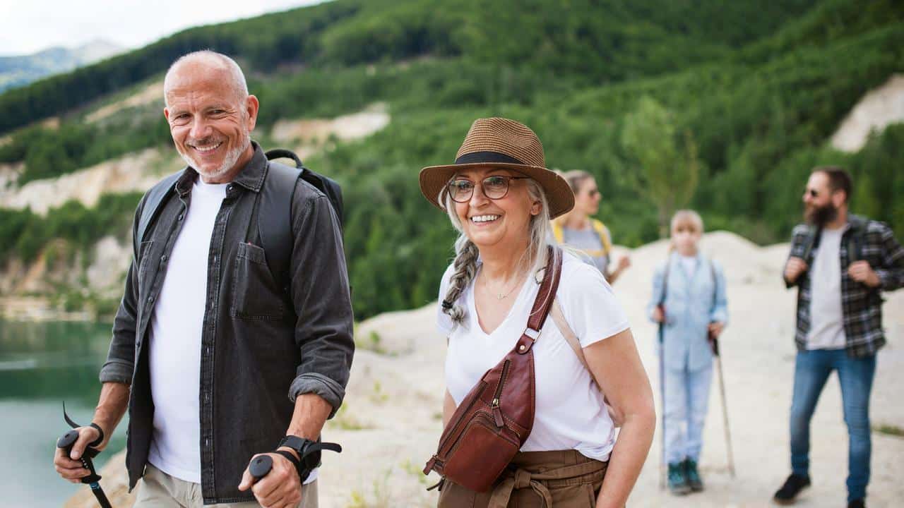 A group of hikers walking along a lakeside trail.