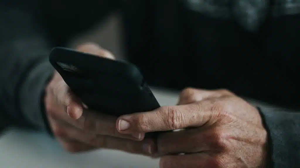 A close-up of hands holding a smartphone.