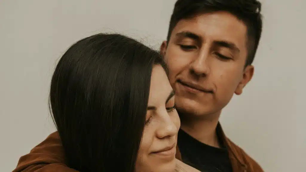 A man hugging the man from the backide.