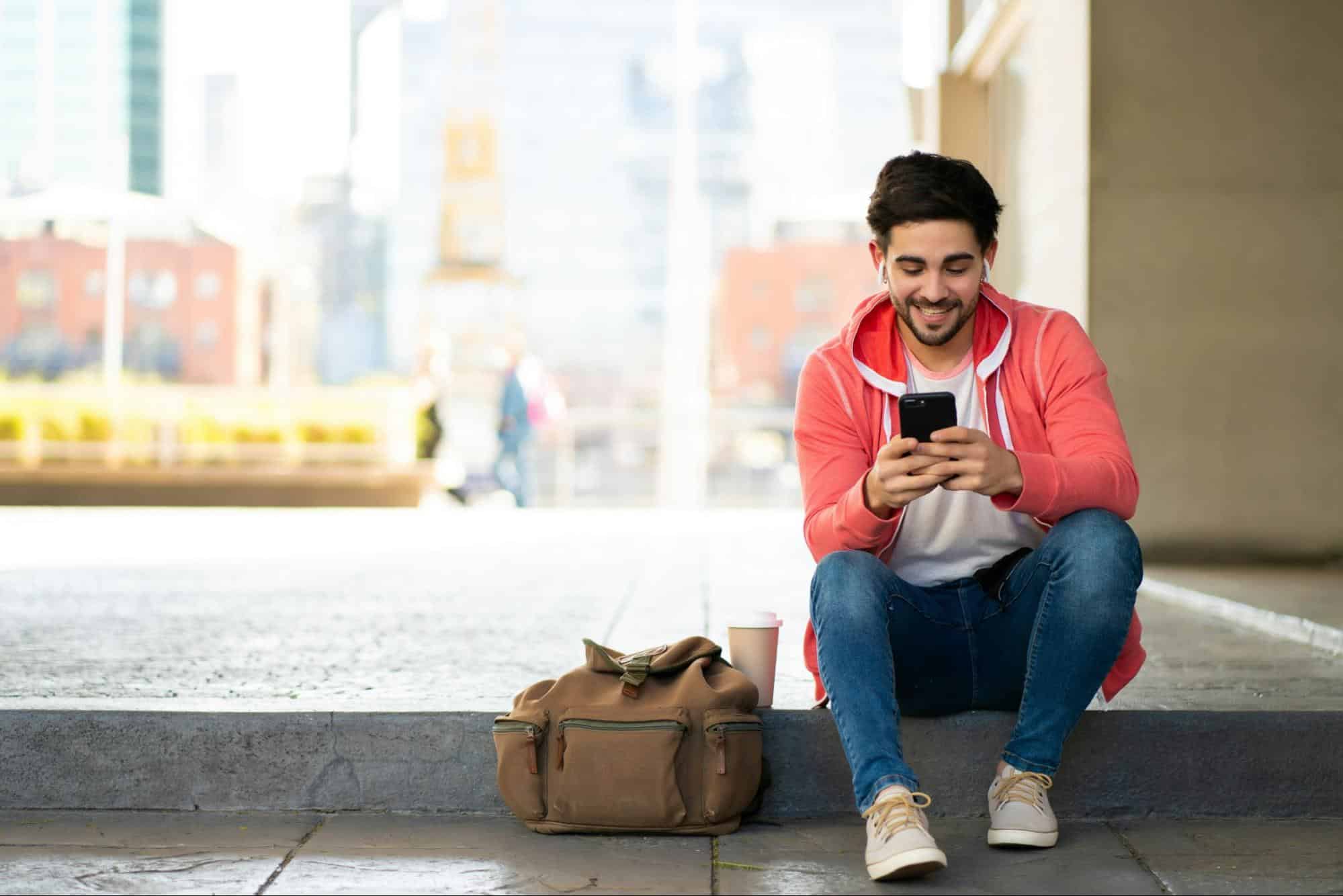 A man smiling while using a phone