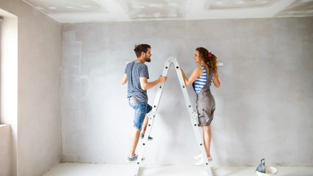 A couple painting the wall.