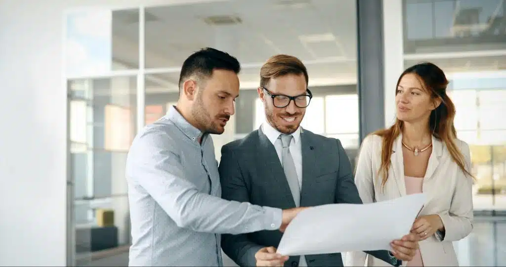 A woman looking at her husband teaching another man