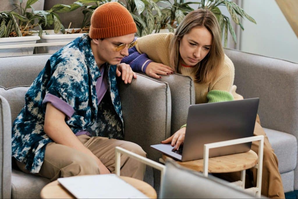 A man and woman looking at the laptop