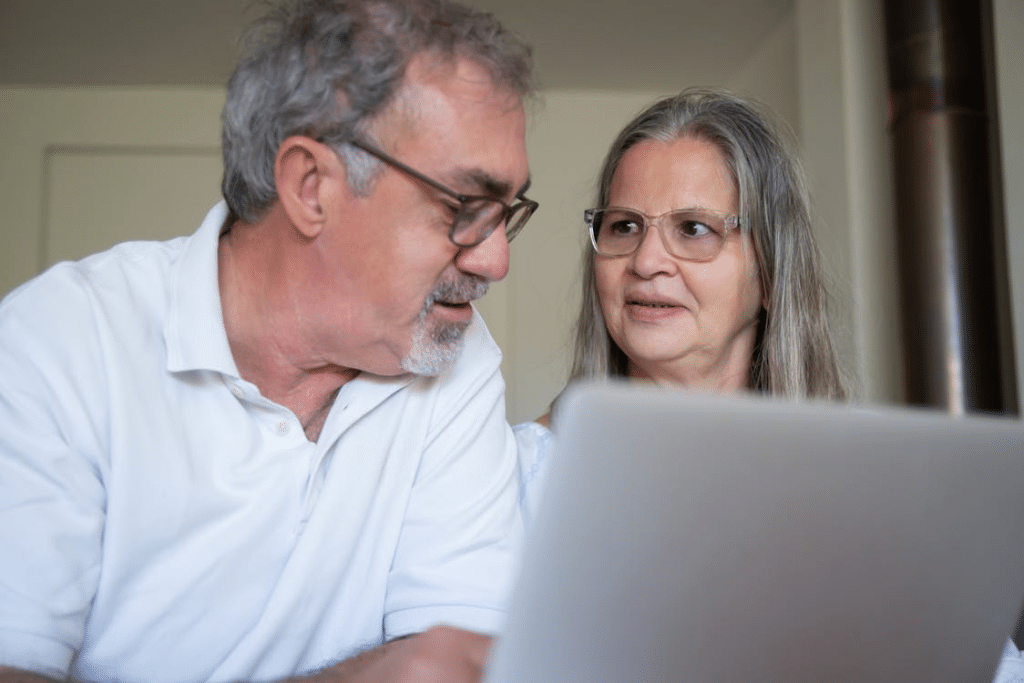 A couple sitting using a laptop