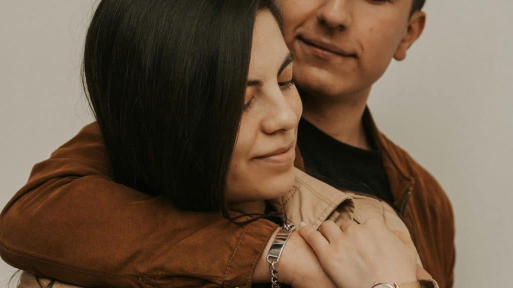 A couple sharing a gentle embrace, with one person resting against the other.
