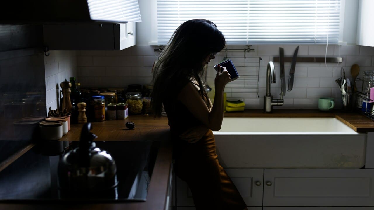 A woman looking sad in the kitchen