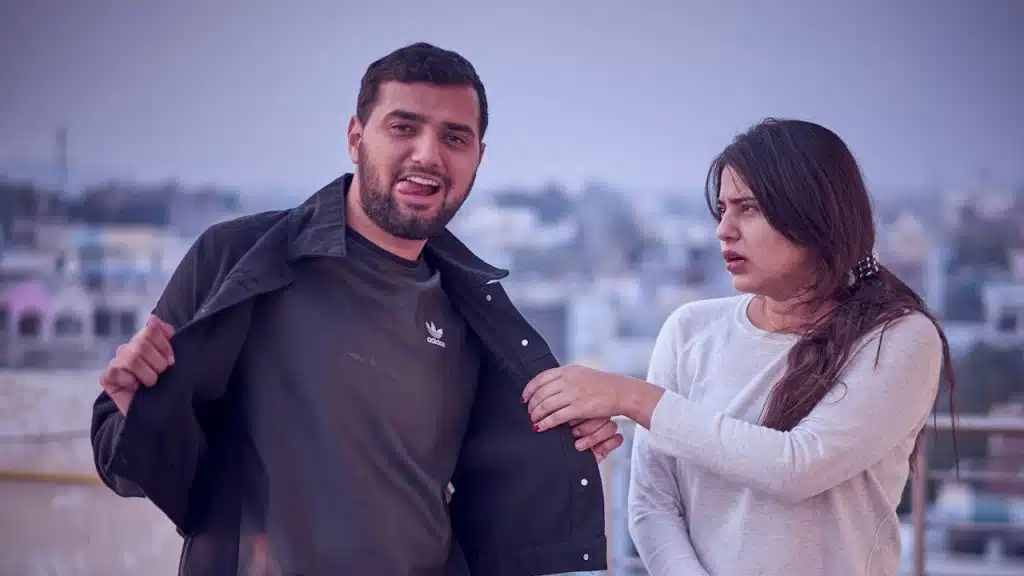 A woman holding her boyfriend’s jacket who is trying to annoy her.