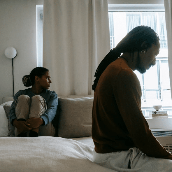 Sad couple during quarrel on bed