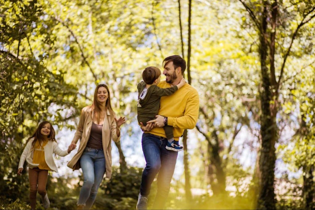 A couple walking at the woods with their children