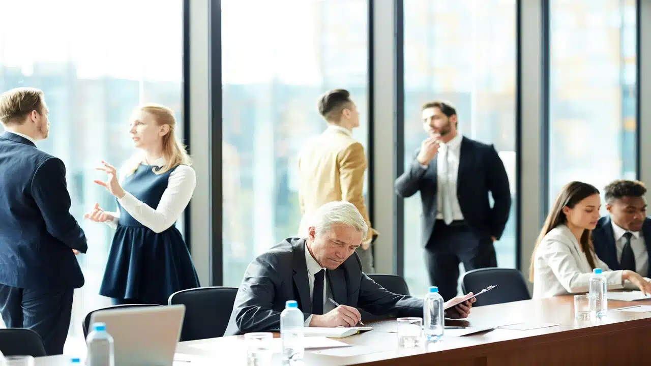 A senior businessman looking calm at a busy office