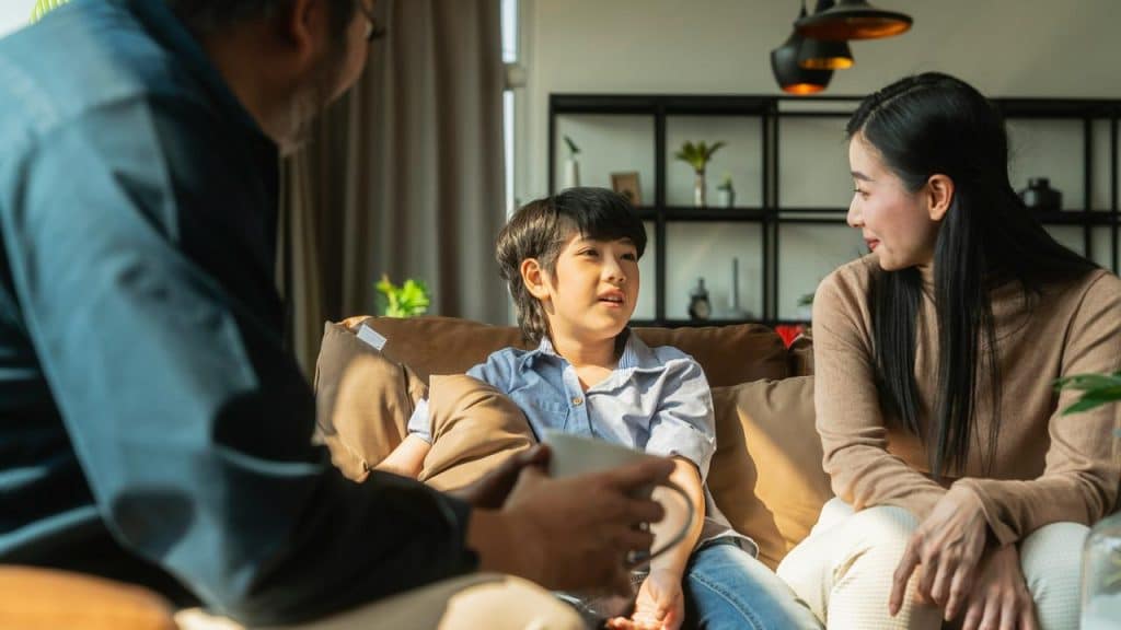 A family of three talking on a couch.