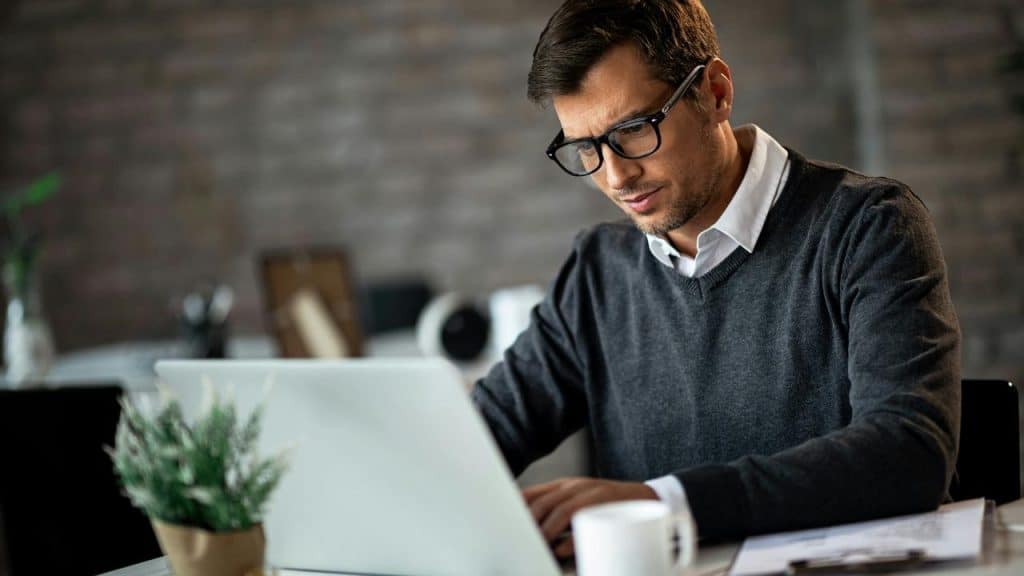 A man working on a laptop at a desk.