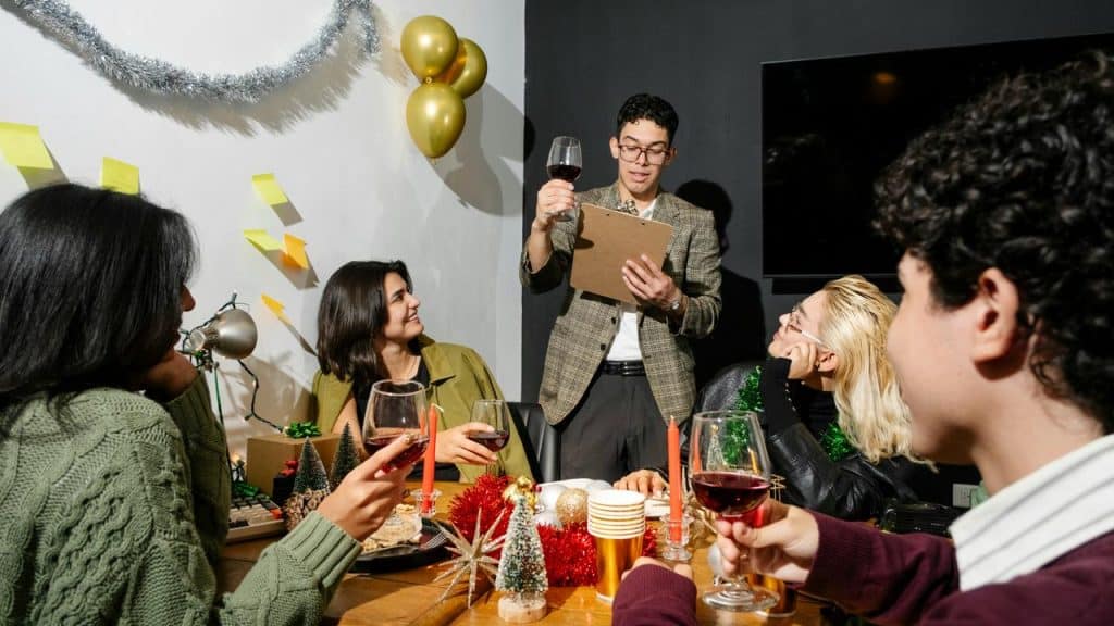 A group of people share drinks while a man gives a toast at a festive gathering.