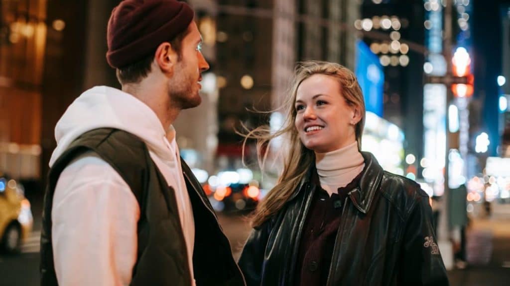 A man speaking sincerely with a woman during an evening walk.