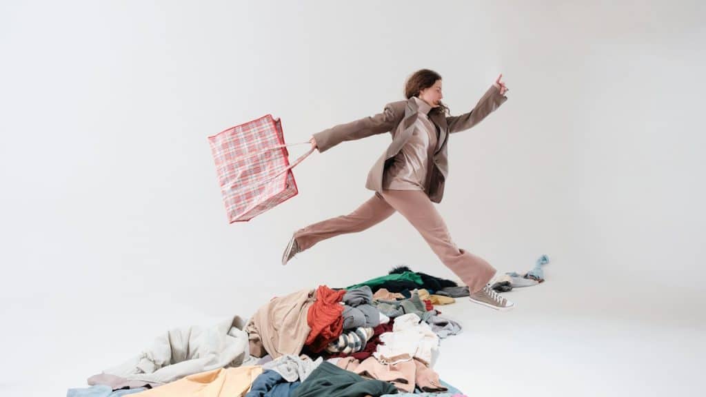 A woman-jumping-in-the-air-over-a-pile-of-clothes.