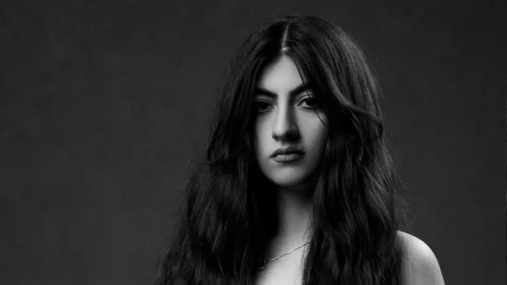A woman with open hair looking at the camera with an intense expression.