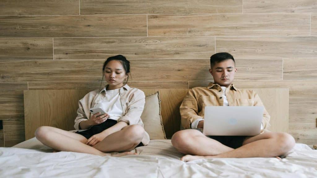 A couple not looking at each other in bed