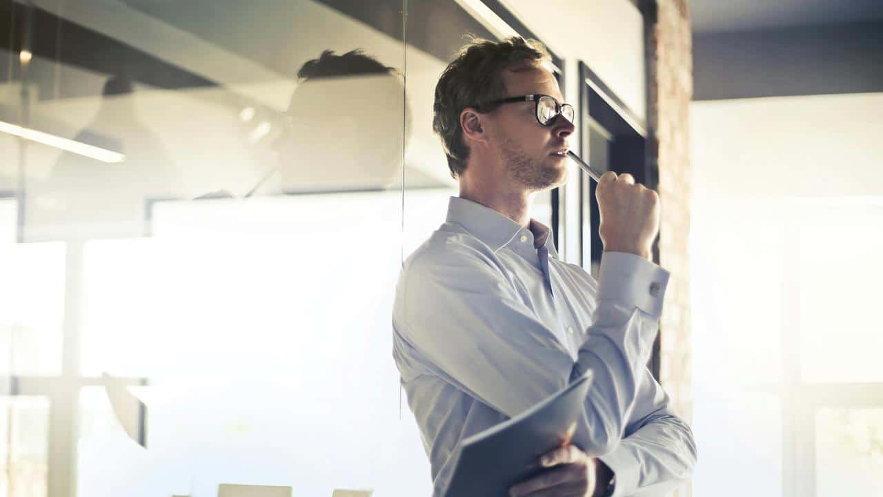 A man pondering with a pen in his hand.