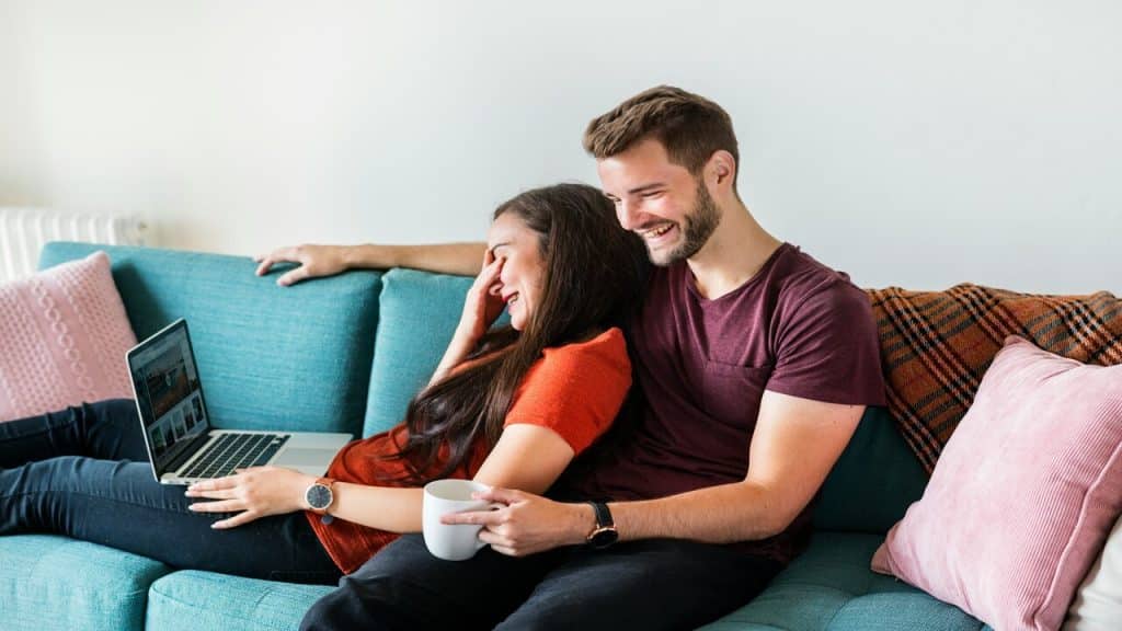 A man laughing while the woman looks embarrassed