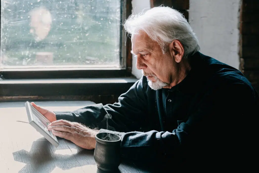 Mature man using tablet sitting down at desk