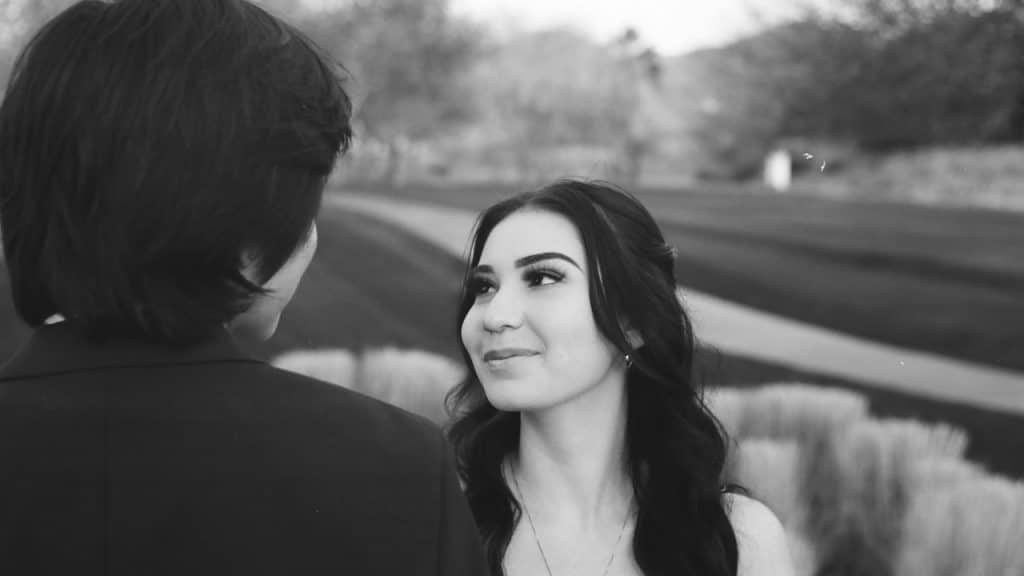 A woman smiling and looking at a man.