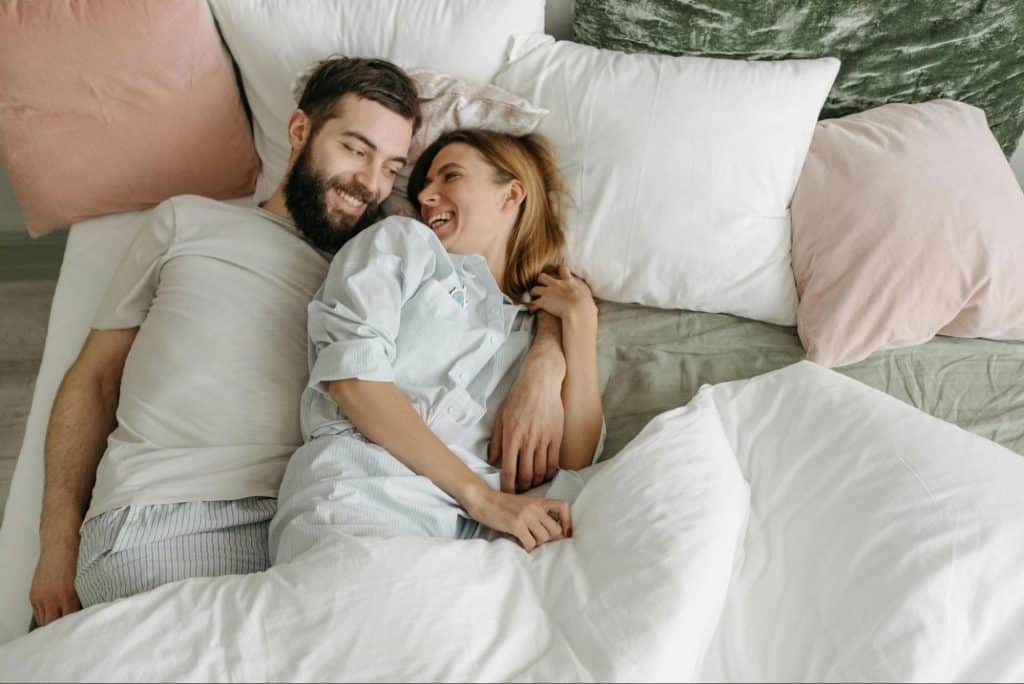 A man and woman having conversations at the bed