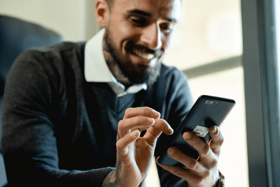 A man texting while smiling