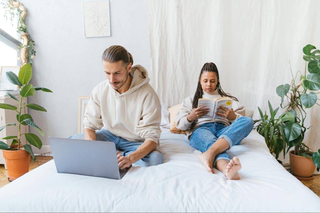A man busy working and a woman reading a book
