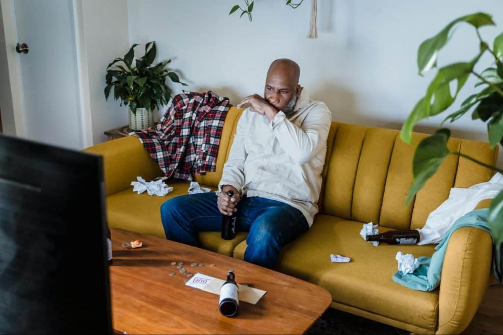 A messy man sitting at the couch 