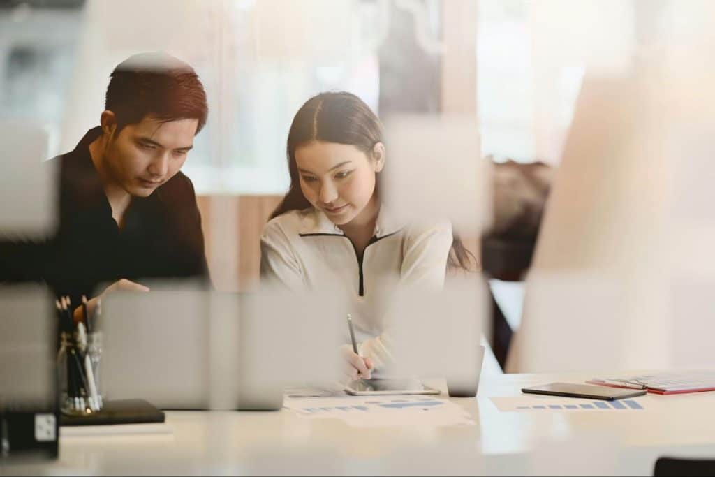 A man and woman looking at the laptop