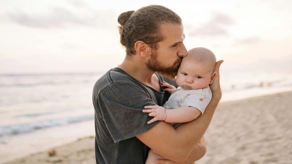 A dad with his baby on the beach 