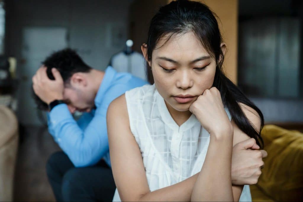 A sad woman and a man behind her