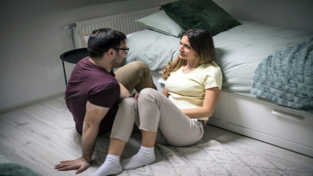 A couple talking on the floor 