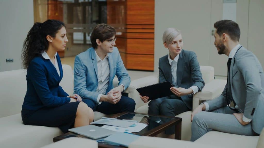 A business team in formal attire discussing documents during a meeting.