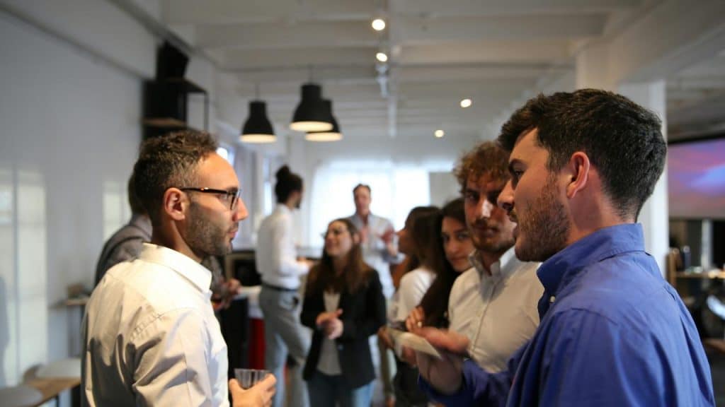 A group of people talking and networking in a bright office space.