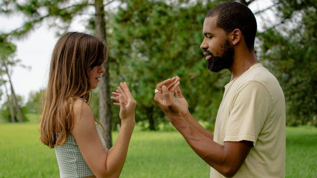 A man standing next to a woman in a field.