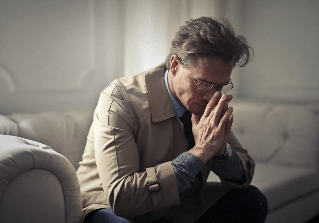 Sad man thinking about problems in living room