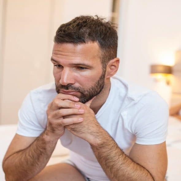 A couple looking sad in bed