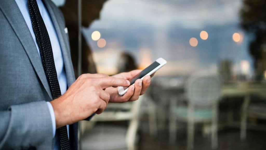 A man in a suit using a smartphone.
