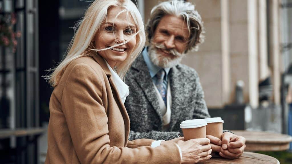 A man and a woman drinking coffee at a cafe.