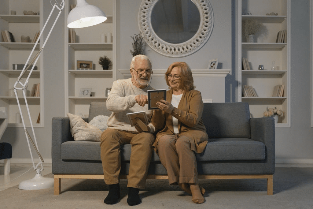 Elderly Couple Looking at Framed Photographs