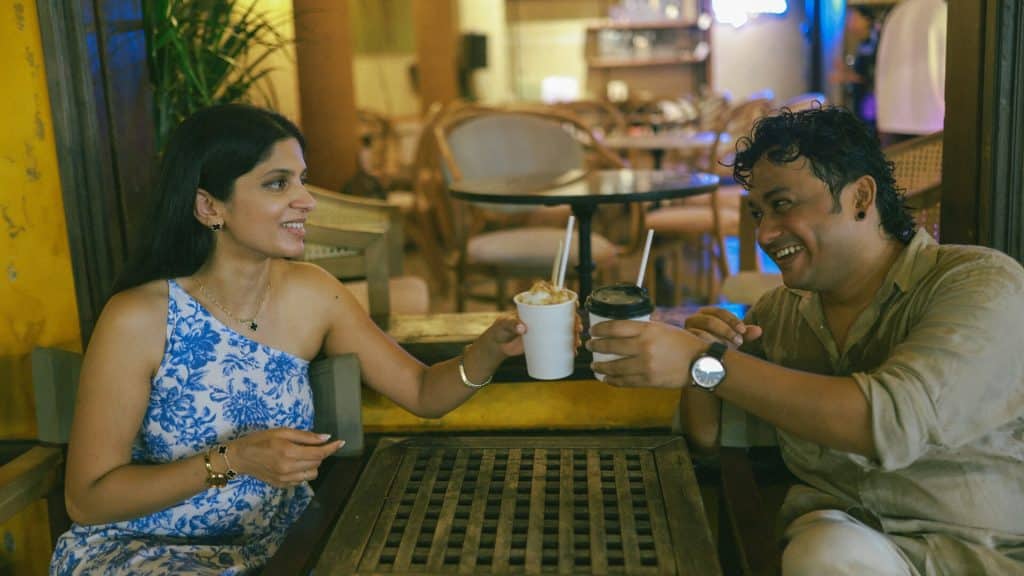 A man and a woman having drinks at a café.