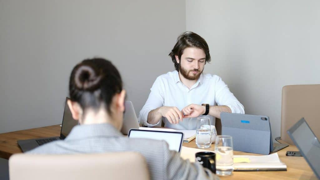 A man checking his watch in a meeting.