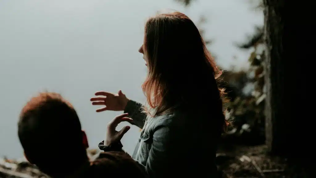 A man and a woman talking about an issue while sitting together.