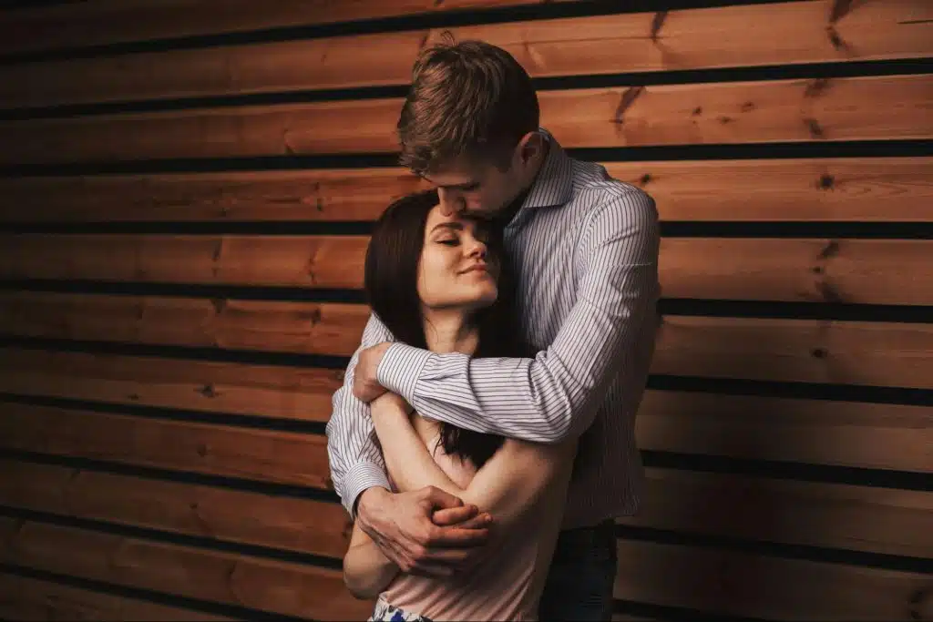 A man kissing a woman’s forehead