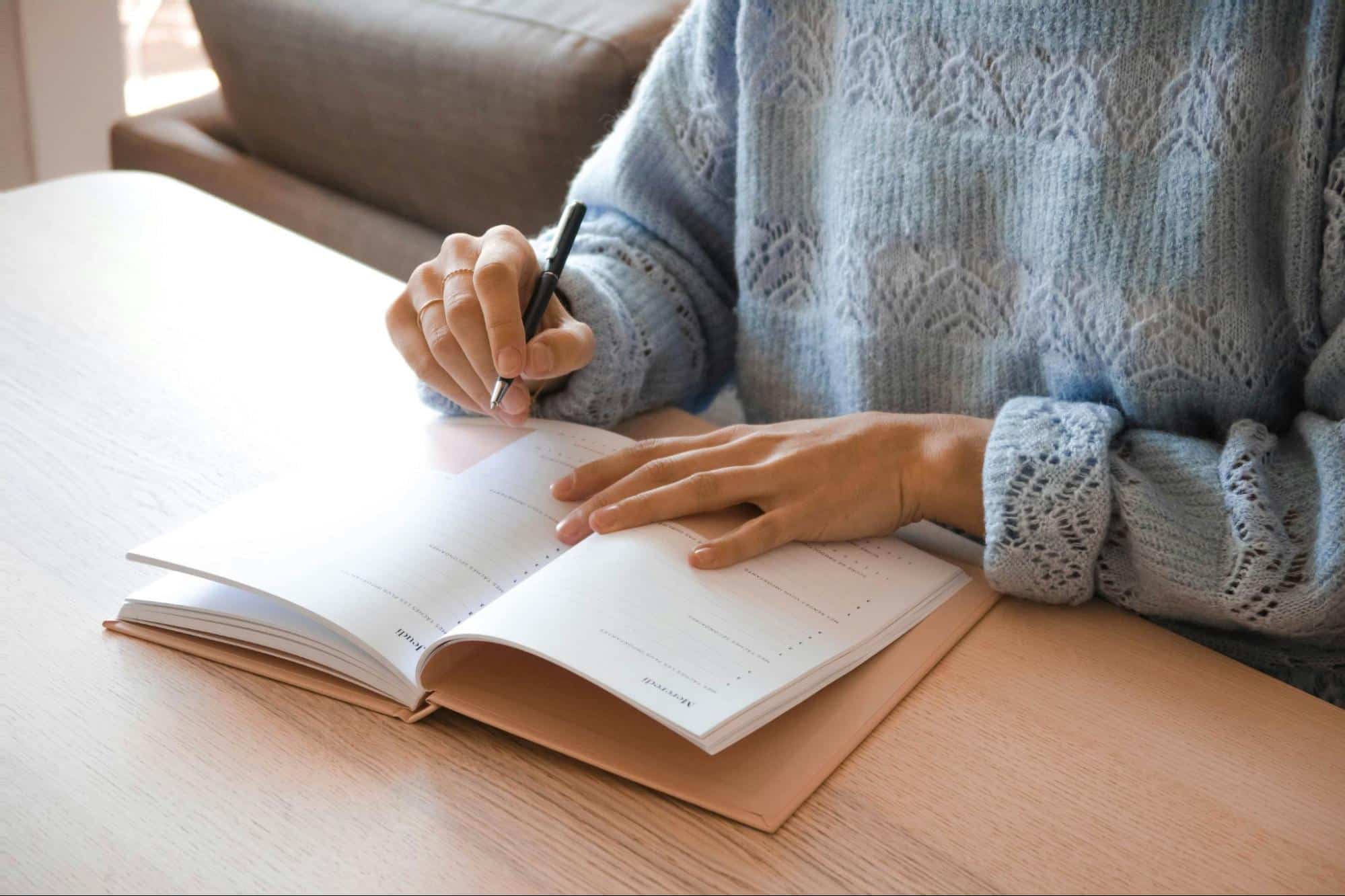 A woman writing at the planner notebook