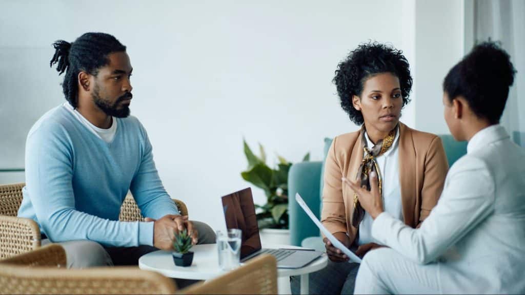 A man and woman talking with their friend