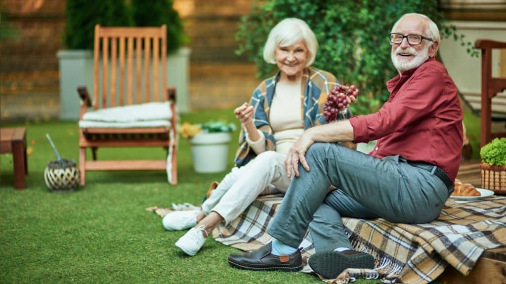 A man and a woman sitting on a lawn in a happy mood.